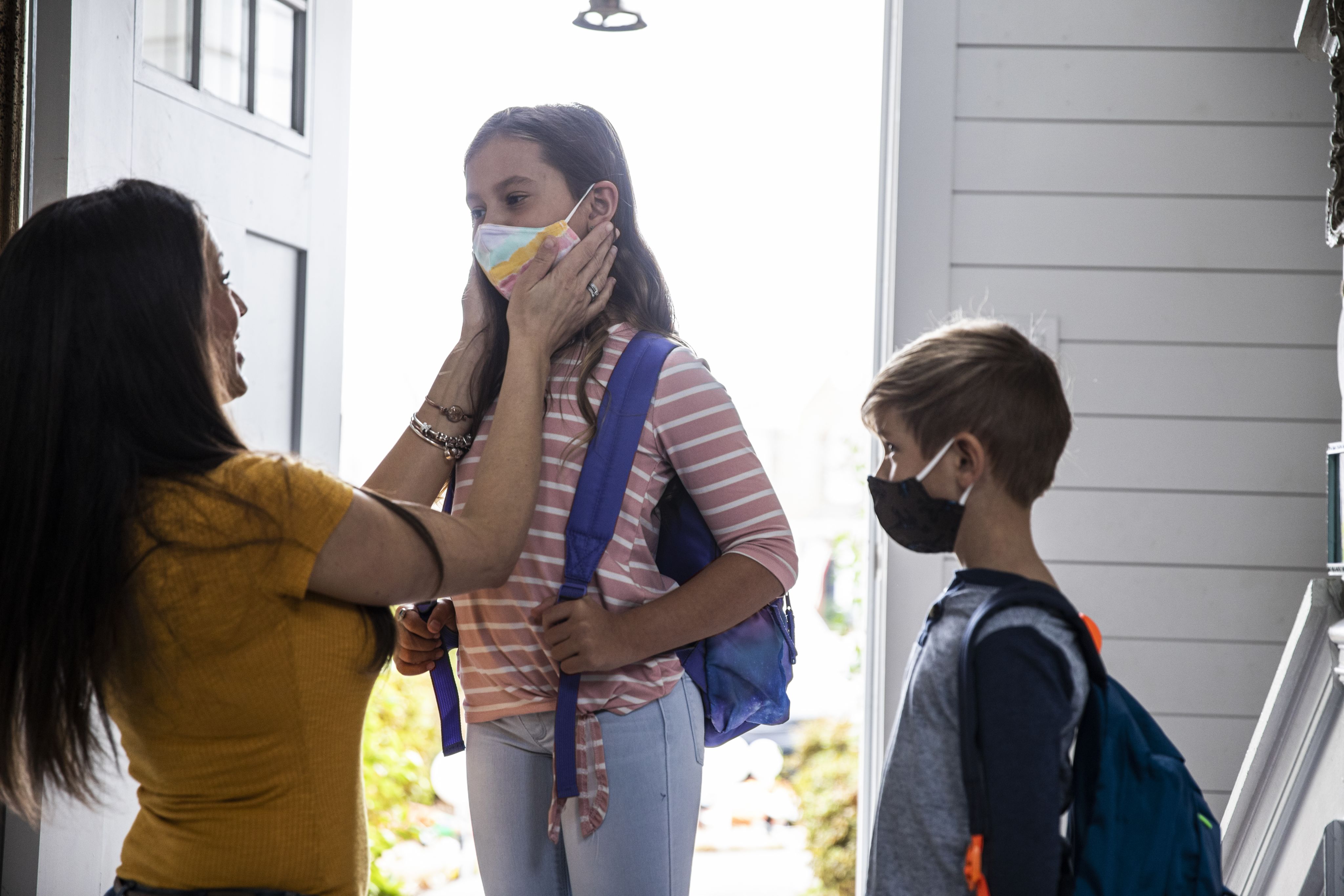 A mother gets her children ready for school.