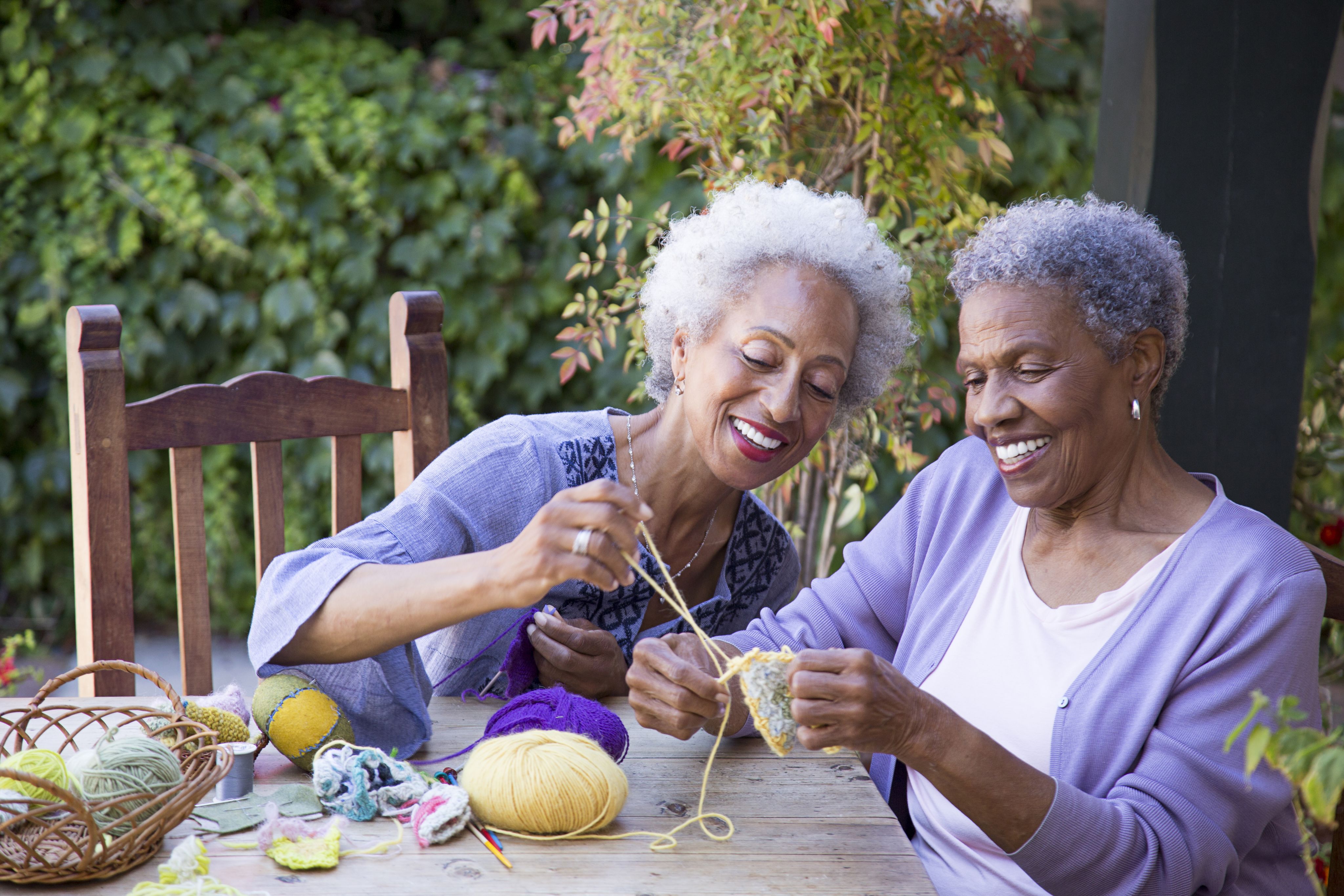 Two women sitting together knitting.