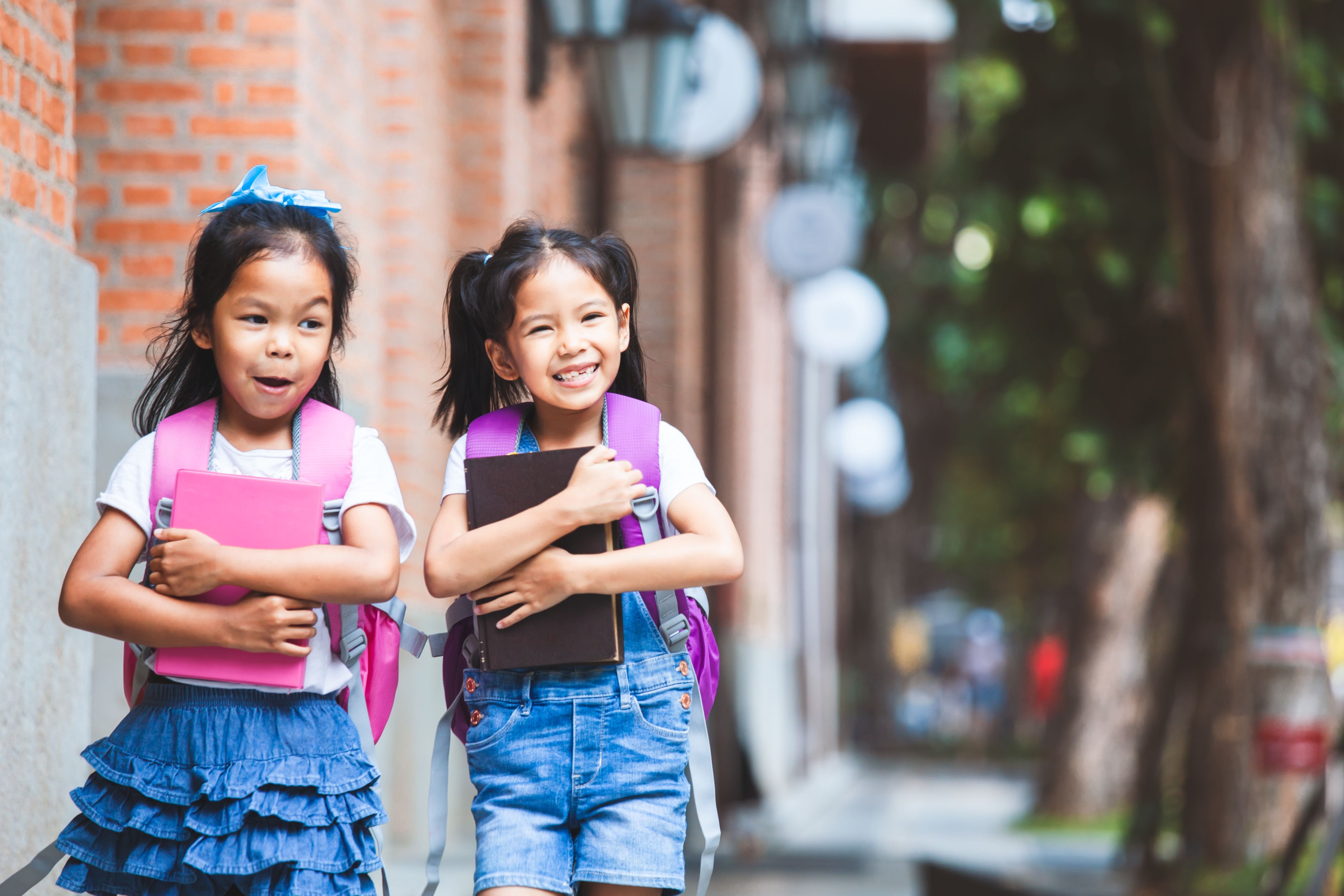 Two young student are walking to school.
