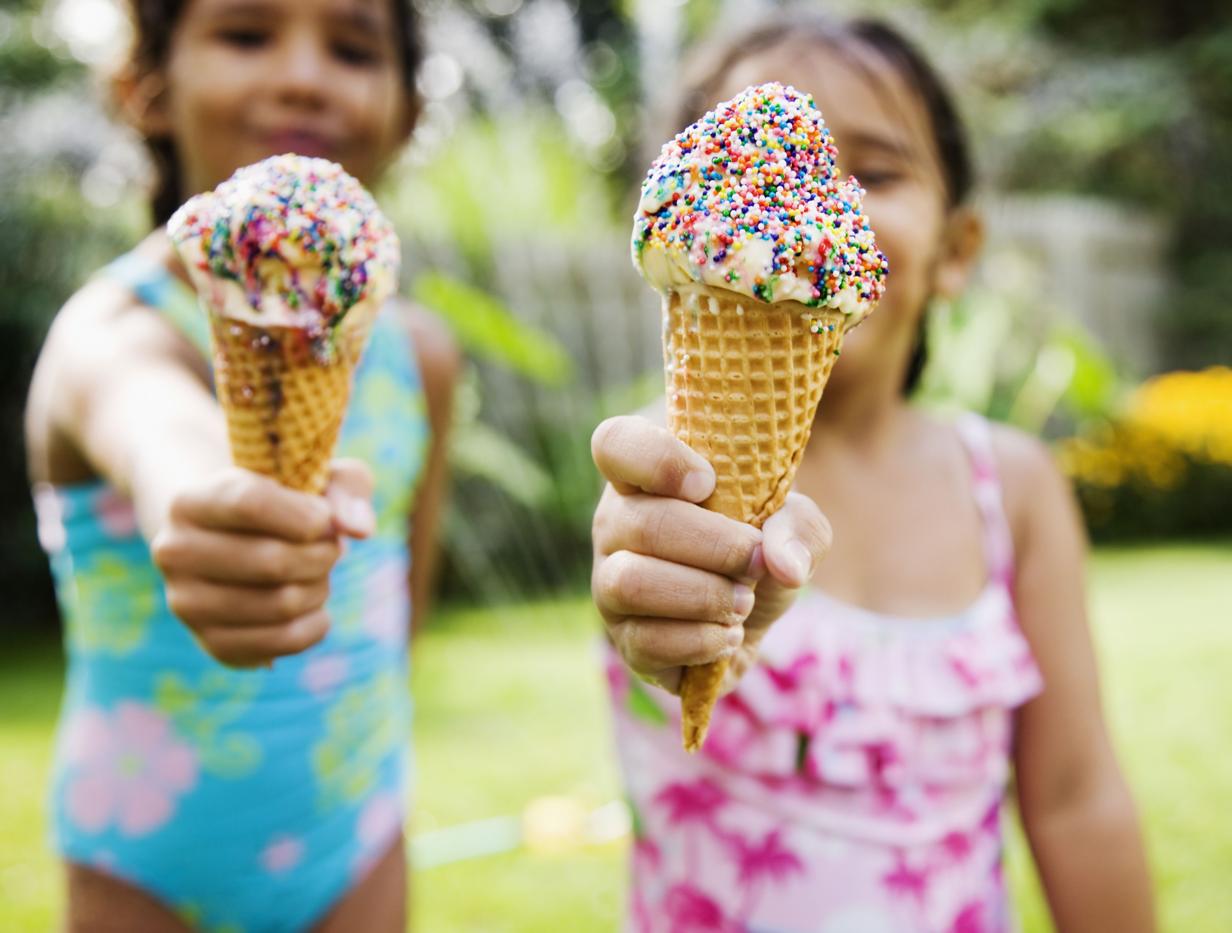 Two girls eating ice cream cones.