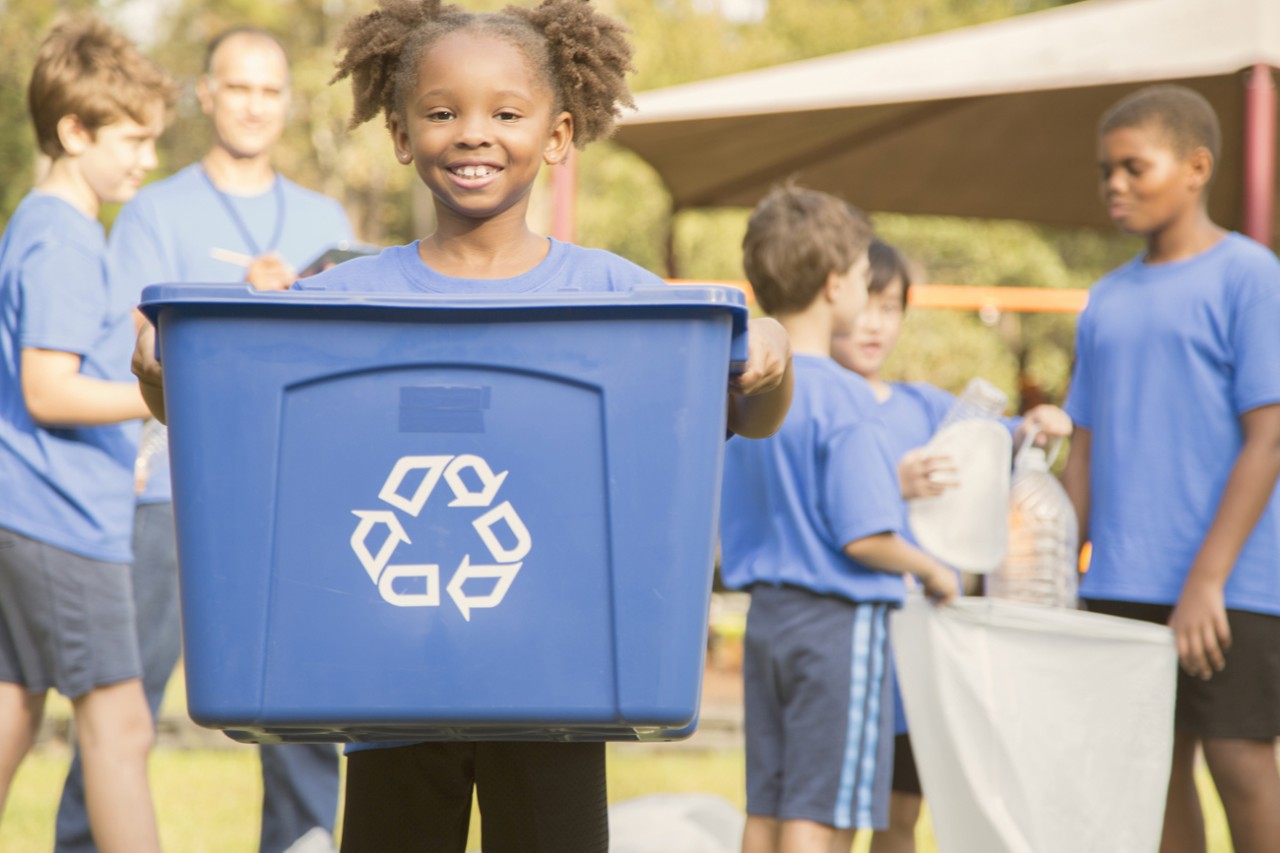 Photo: Girl holding recycling bin